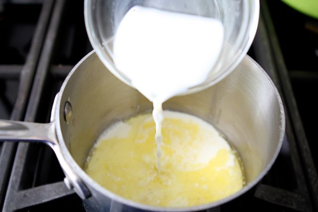 Subimosa fuego medio alto y a la mezcla se le agrega leche condensada, leche y se revuelve hasta que comience a hervir
