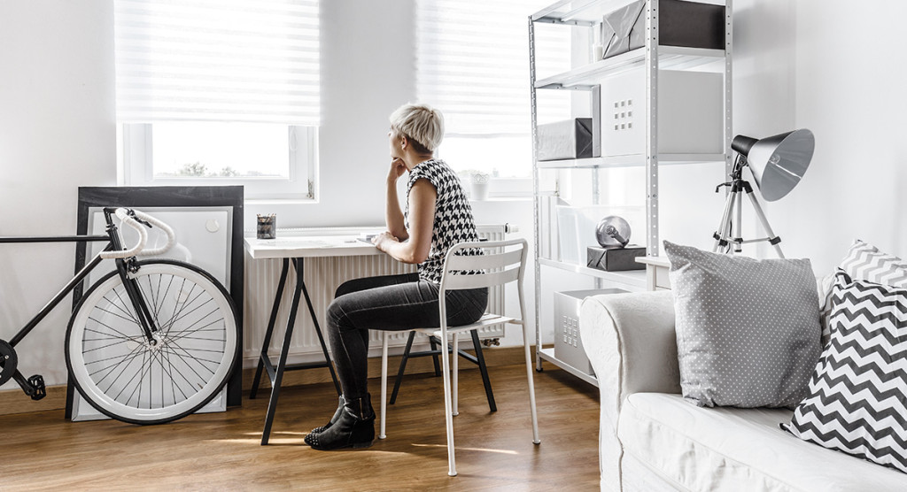 Mujer sentada en su cuarto estilo minimalista decorado en blanco y negro